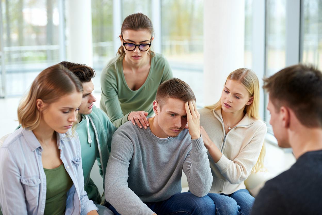 группа людей поддерживают учатника терапевтического сообщества